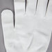 A pack of white Cordova nylon work gloves with a thumb and index finger.