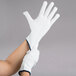 A person wearing Cordova white nylon work gloves.