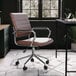 A Martha Stewart brown faux leather swivel office chair at a black desk.