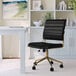 A Martha Stewart black faux leather swivel office chair with gold accents in front of a white desk.