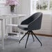 A Martha Stewart gray velvet office chair with an oil-rubbed bronze finish next to a black desk.