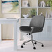 A Martha Stewart gray faux leather office chair with wheels at a desk.