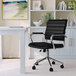 A Martha Stewart black faux leather office chair with wheels.
