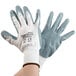 A person wearing white Cordova Cor-Touch gloves with gray foam nitrile palms.