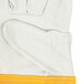 A white Cordova leather welder's glove with yellow stitching.