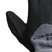 A close-up of a pair of gray Cordova Conquest Xtra gloves with black palm coating.