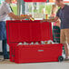 A group of men standing next to a red CaterGator cooler.