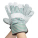 A person wearing Cordova green and white striped work gloves.