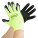 A pair of hands wearing small yellow Cordova warehouse gloves with black foam latex coating.