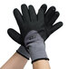 A pair of Cordova Conquest Max gray and black gloves with nitrile dots.