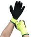 A pair of hands wearing hi-vis green Cordova loop-in terry gloves with black foam latex palms.