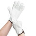 A pair of small Cordova white leather gloves with brown trim on the forefingers.