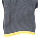 A close up of a grey and yellow knit glove with a yellow trim.