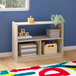 A Flash Furniture wooden open storage unit with a shelf holding boxes and toys in a white room.