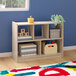 A Flash Furniture wooden open storage unit with 5 compartments filled with boxes and toys.