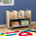 A Flash Furniture wooden mobile storage cart with clear storage bins and toys and books on the shelves.