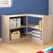 A Flash Furniture wooden corner shelf unit filled with books and toys.