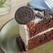 A slice of chocolate cake with Oreo cookies on top.