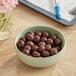 A bowl of Albanese milk chocolate covered espresso beans on a table.