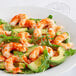 A white plate with Beleaf Plant-Based Vegan Jumbo Shrimp and avocado salad.