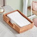 A wicker basket on a kitchen counter filled with Earthwise white guest towels.