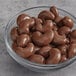 A glass bowl of Albanese Milk Chocolate Covered Cashews.