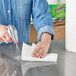 A hand using a Bounty paper towel to clean a counter on a professional kitchen counter.