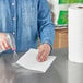 A person using a sprayer to clean a table with a Bounty paper towel.