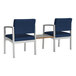 Two Lesro Lenox arm chairs with blue fabric next to a Sarum Twill laminate table.