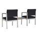 Two Lesro Lenox steel arm chairs with black vinyl seats next to a Sarum Twill laminate table.