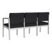 A row of Lesro Lenox black steel chairs with black vinyl cushions.
