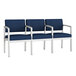 A row of Lesro Lenox steel chairs with navy blue fabric and white legs.