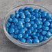 A bowl of Blue Milk Chocolate Gems on a table.