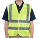 A man wearing a Cordova lime yellow high visibility safety vest over a black shirt.
