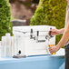 A man pouring a beer from a white CaterGator insulated jockey box.