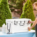 A man using a white CaterGator jockey box with taps to pour a drink.