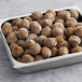 A metal tray filled with Impossible Foods plant-based vegan meatballs.