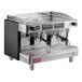 A silver and black Estella Caffe Two Group Teapresso Machine on a counter with three black handles.