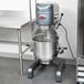 An Avantco 40 qt. floor mixer with guard on a stainless steel stand.