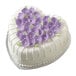 A heart-shaped cake with purple flowers on top in a Wilton Decorator Preferred heart-shaped cake pan.