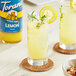 A pair of glasses of lemonade with lemon slices and a lemon wedge using Torani Sugar-Free Lemon Fruit Syrup.