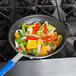 A Vollrath Wear-Ever aluminum non-stick fry pan filled with colorful peppers and vegetables.