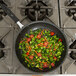 A Vollrath Wear-Ever fry pan filled with vegetables on a stove.