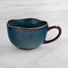 An Acopa Highlands skyfall blue ceramic cup with a brown rim.