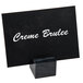 An American Metalcraft black marble table card holder with a white sign on it.