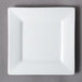 A 10 Strawberry Street Whittier white square porcelain salad/dessert plate with a small rim on a gray surface.