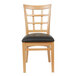 A Lancaster Table & Seating wooden window back chair with black vinyl seat.