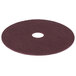 A maroon circular Scrubble conditioning floor pad with a hole in the middle.