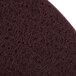 A close-up of a maroon Scrubble conditioning floor pad.