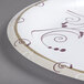 A close up of a Solo Symphony white paper plate with swirl designs.